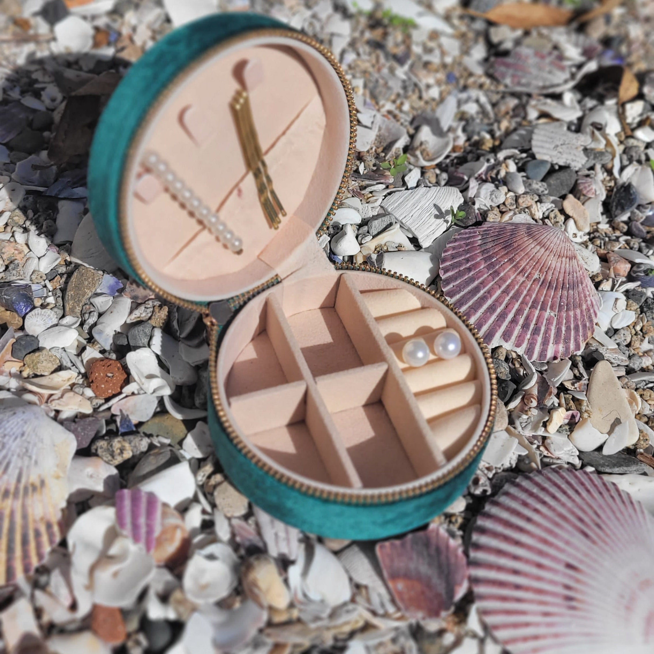 Joyero pequeño, redondo, con exterior de terciopelo verde. Al interior, de color crema, cuenta con compartimientos para organizar tus joyas y accesorios. 