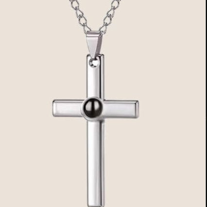 Collar Unisex, color plata, de acero inoxidable. Cuenta con una cruz, la cual en el centro tiene una gema que guarda una foto personalizada. 