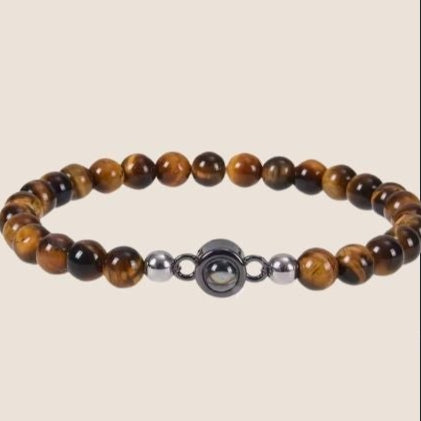 Pulsera unisex, con cuentas redondas color café, y al centro una gema que contiene una foto personalizada. 